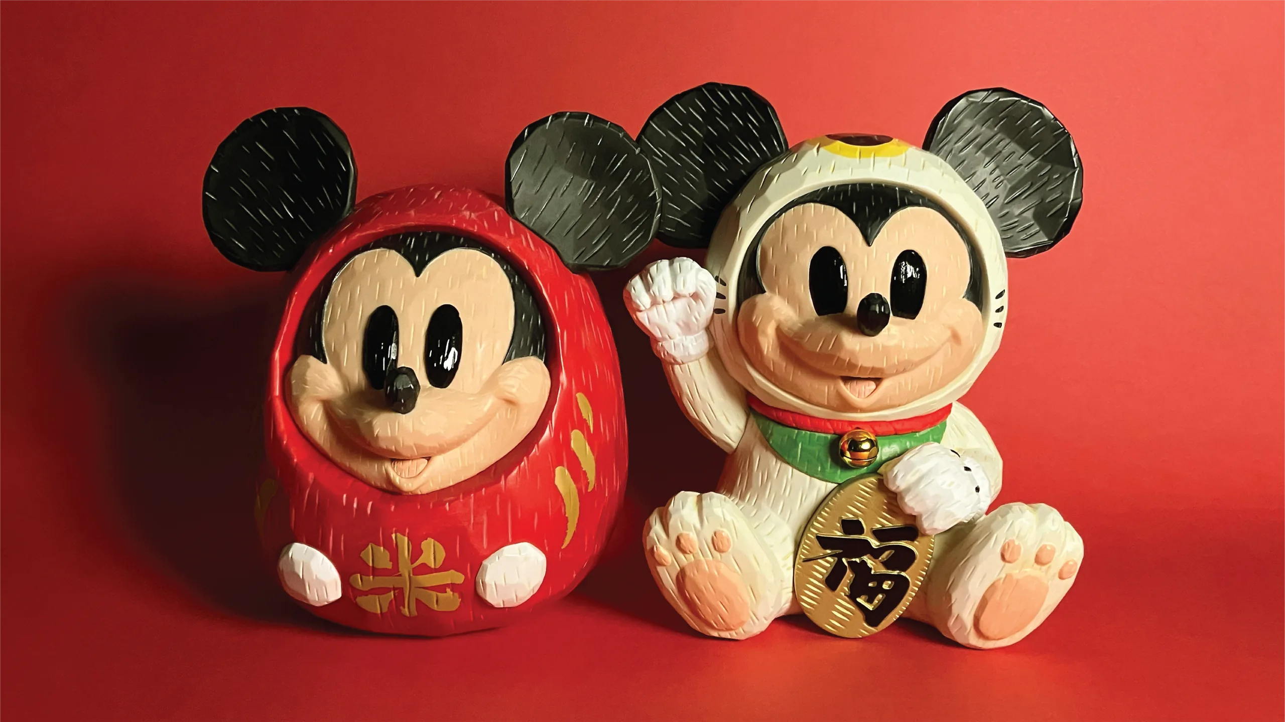 Mickey-inspired daruma and lucky cat figures on a red background